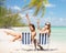 Happy young women with drinks sunbathing on beach