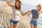 Happy young women strolling along coastline on a sunny day. Two female friends walking together on a beach, enjoying