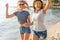 Happy young women strolling along coastline on a sunny day. Two female friends walking together on a beach, enjoying