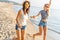 Happy young women strolling along coastline on a sunny day. Two female friends walking together on a beach, enjoying