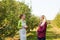 Happy young women talking in apple garden