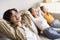 Happy youngsters japanese girl, millennial mother relax, father with hand behind head look at camera on couch