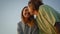 Happy youngsters kissing blue sky background closeup. Young woman throwing rock