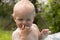 Hapyy adorable curly baby boy playing with water in swimming pool on a sunny summer day