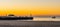 The harbor pier at the beach of blankenberge, Belgium, a boat sailing in the sea, beautiful sunset and colorful sky