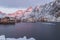 Harbor, rorbuer and snowy mountains at sunrise in A, Lofoten, No