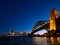 Harbour Bridge and Sydney city skyline at night against bright dark blue sky