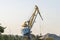 Harbour cranes are loading sand and gravel on a barge. Loading materials by crane