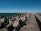 Harbour wall in Povoa de Varzim, Portugal with breakwater boulders and and city in distance