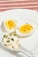 Hard boiled egg and ceramic spoon of mayo with parsley