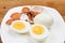 Hard boiled egg with peeled and shattered shells on plate