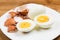 Hard boiled egg yoke with peeled and shattered shells on plate