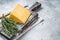 Hard cheese with knive on wooden cutting board. Parmesan. Gray background. Top view. Copy space