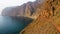 Hard difficult road on Tenerife Island with beautiful seascape. Dangerous narrow path along the edge of the sheer cliffs