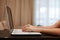 The hard hands of a businessman are typing on a laptop keyboard against the background of a blurred room. Concept for workplace,