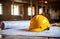 a hard hat sits on top of red blueprints on a table