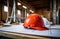 a hard hat sits on top of red blueprints on a table