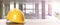 Hard hat on white surface at construction site with unfinished building, banner design. Space for text