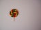 A hard sweet on a stick. Colorful lollipop swirl. Striped spiral multicolored candy