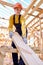 Hardworking female working on wooden construction site, wearing working uniform clothes