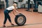 Hardworking girl changing a tyre at workshop