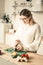 Hardworking long-haired woman in knitted sweater using cooking tools