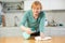 Hardworking mature woman cleaning the kitchen with cleaning products