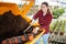 Hardworking young farmer woman fills a flower pot with nutritious soil