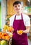 Hardworking young salesman puts fresh oranges on the counter