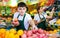 Hardworking young salesman puts pomegranates on the counter