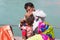 Haridwar, India - March 20, 2017: Man shaving off hairs for young Hindu devotee initiation on the Ganges River at Haridwar, India.