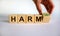 From harm to harmony. Male hand turns the cube and changes word `harm` to `harmony`. Beautiful white background. Business and