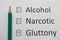 Harmful habits: alcohol, drugs, gluttony are written on white paper in pencil. Get rid of bad habits.