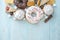 Harmful sweet foods on blue wooden background. Donuts and muffins on the table pile. Unhealthy diet and overweight