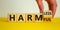 From harmful to harmless. Male hand turns the cube and changes word `harmful` to `harmless`. Beautiful yellow table, white