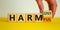 From harmful to harmony. Male hand turns the cube and changes the word `harmful` to `harmony`. Beautiful yellow table, white