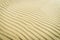 Harmonic pattern of rippled sand surface on beach. Climate change, global warming concept.