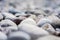 A harmonious background or closeup of smooth natural rocks or round beach pebbles at the beach