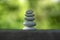 Harmony and balance, cairns, simple poise pebbles on wooden table, natural green background, simplicity rock zen sculpture