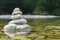 Harmony, balance and simplicity concept. A stone pyramid on the background of river water. Simple poise pebbles, rock zen