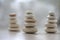 Harmony and balance, three cairns, simple poise pebbles on wooden light white gray background, simplicity rock zen sculpture