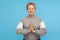 Harmony healing, yoga. Tranquil woman with short curly hair in sweatshirt doing namaste gesture and praying with closed eyes,