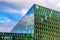 The Harpa Concert Hall and Conference Centre in Reykjavik old harbour. Detail of the exterior glass and steel facade with blue sky