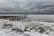 Harsh winter view of the Black Sea coast. Odessa. Huge ice floes and pier in outgrowths of ice and icicles.