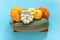 Harvest colored different vegetables gourds pumpkin, zucchini, squash in a wooden box on blue background. Top view Flat lay