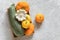 Harvest colored different vegetables gourds pumpkin, zucchini, squash in a wooden box on gray stone background. Top view Flat lay