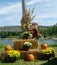 Harvest display with pumpkins, hay bales and happy scarecrow