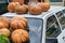 Harvest Festival, bright large pumpkins ready for sale at the street fair are located on the hood and roof of a passenger car.