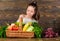 Harvest festival concept. Kid farmer with harvest wooden background. Girl kid rustic style farmers market with fall