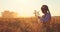 Harvest on golden wheat field. Combine  and bulgarian girl with folklore dress during harvesting